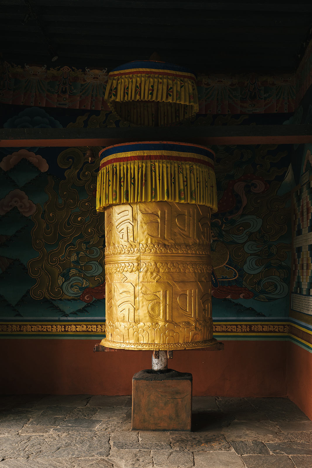 Large golden prayer wheel inside a Bhutanese monastery